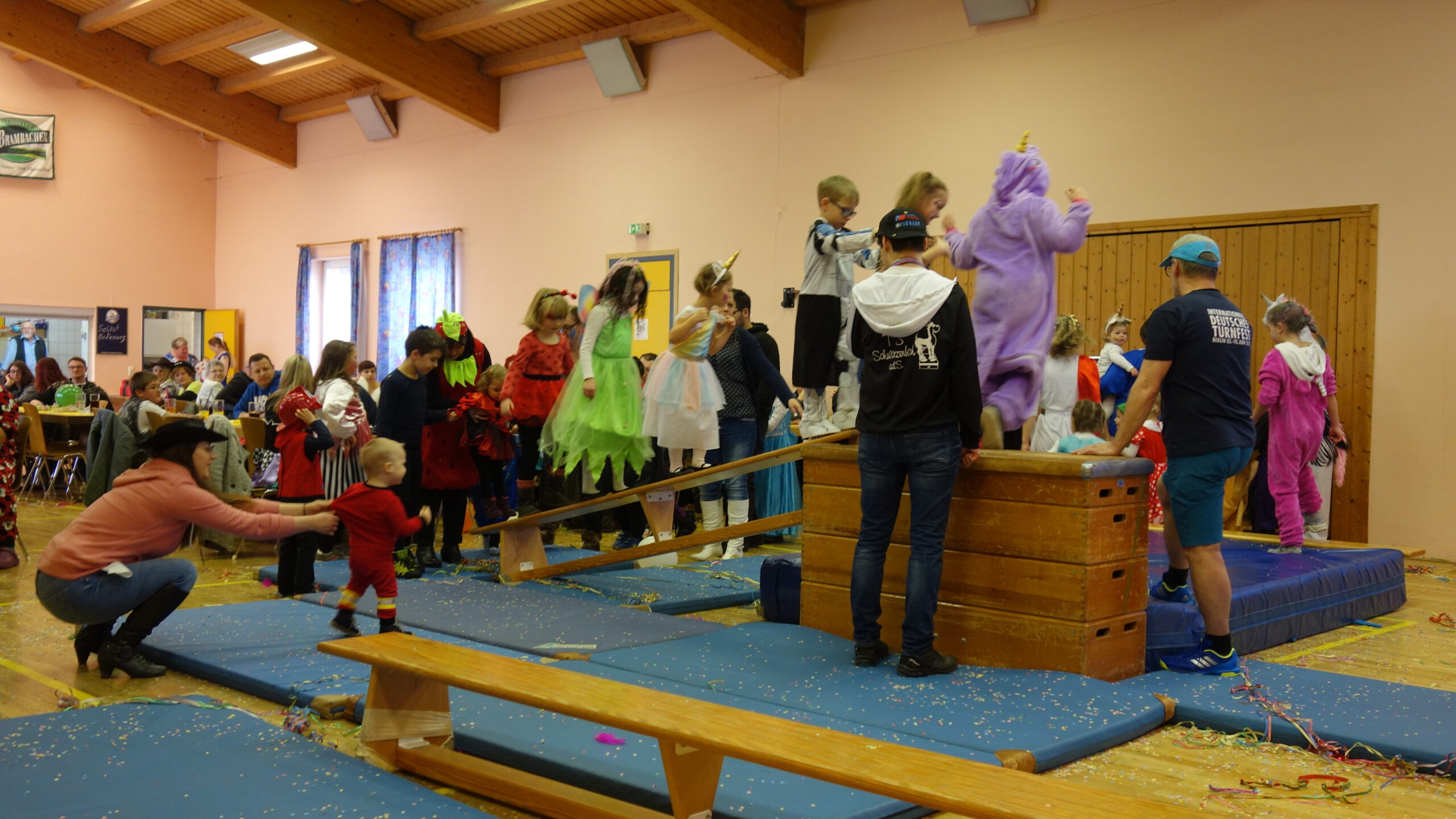Kinder turnen und spielen in Kostümen an einem Kasten mit Langbänken